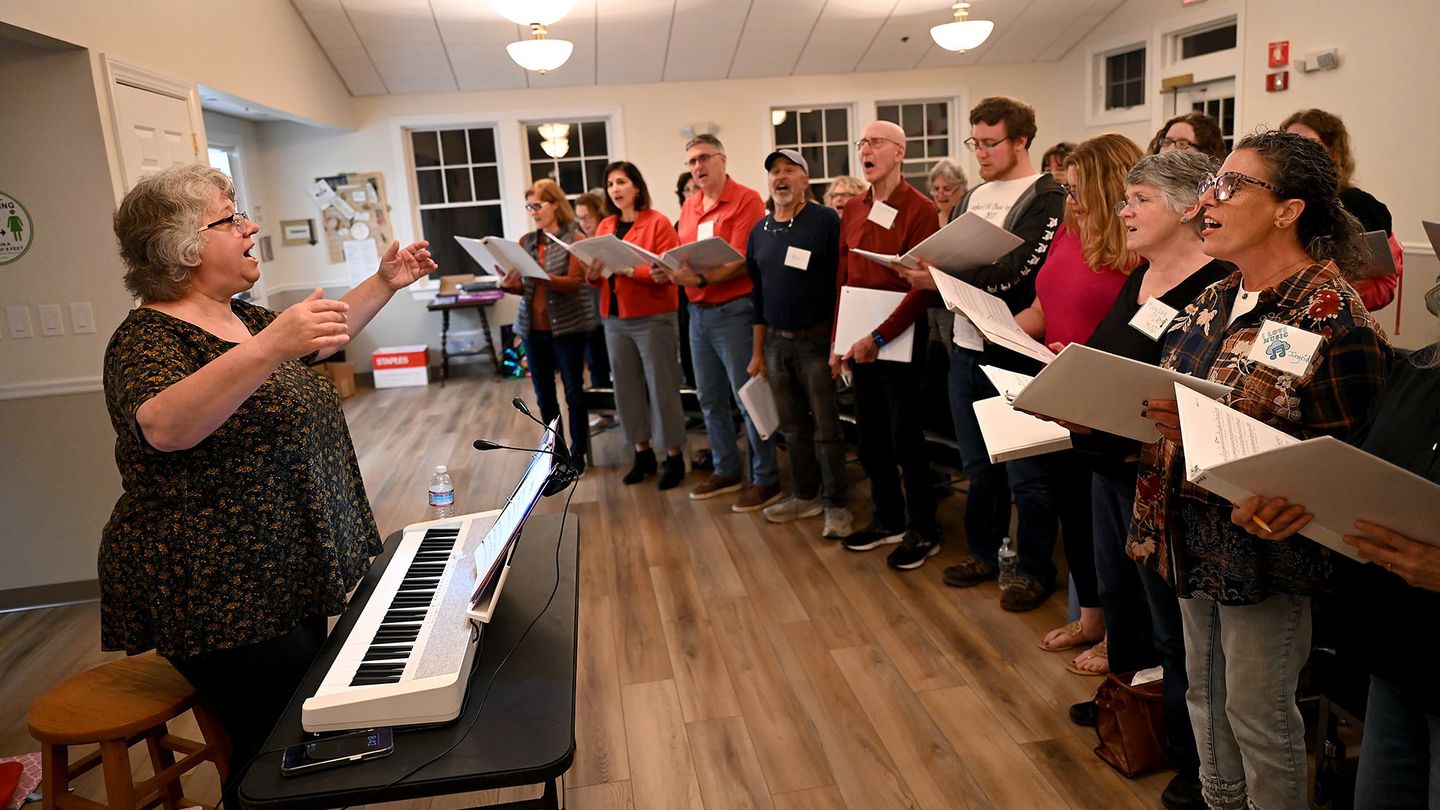 Director Connie Galli leads the Rock Voices community choir in singing the 1970 Simon & Garfunkel tune “Cecilia” in Framingham.